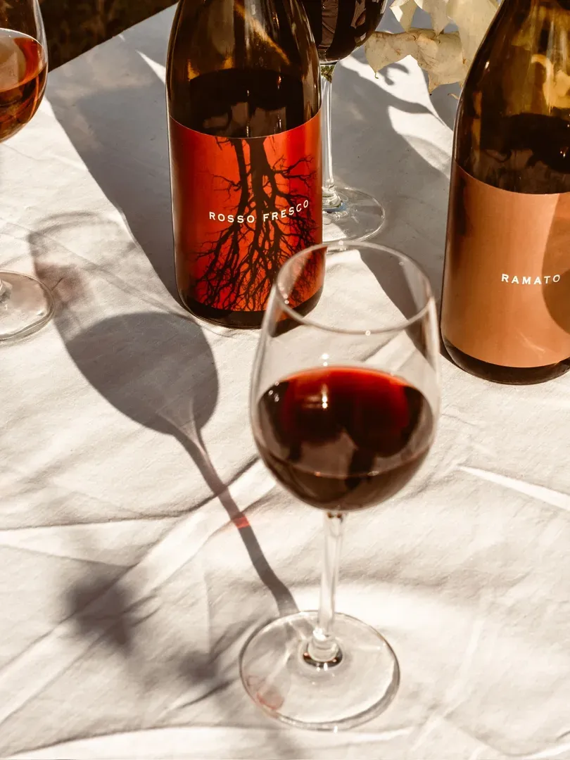 A glass of red wine on a table with a white tablecloth.